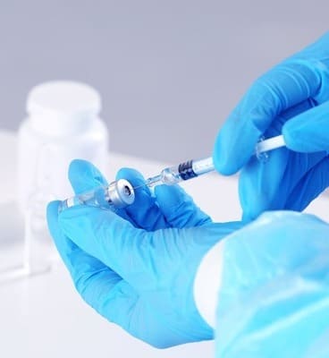 Врач набирает лекарство из пузырька